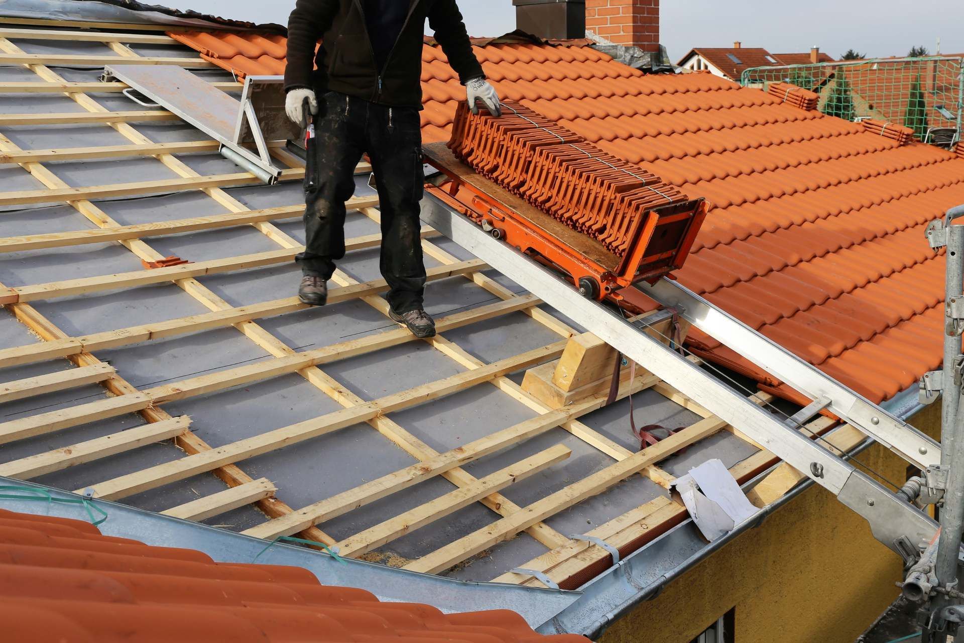 RW Dach GmbH & Co. KG – Dachdecker steht auf einem Schrägdach