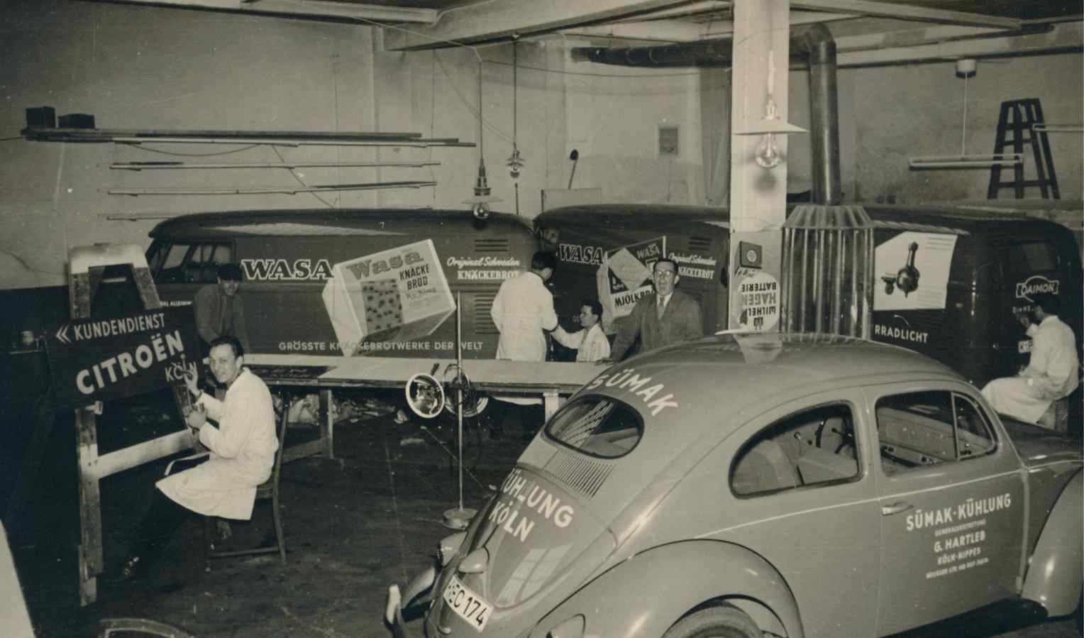 Schwarz-Weiß Bild aus der Werkstatt mit folierten PKWs der Werbetechniker-Innung Köln, Bonn und Aachen