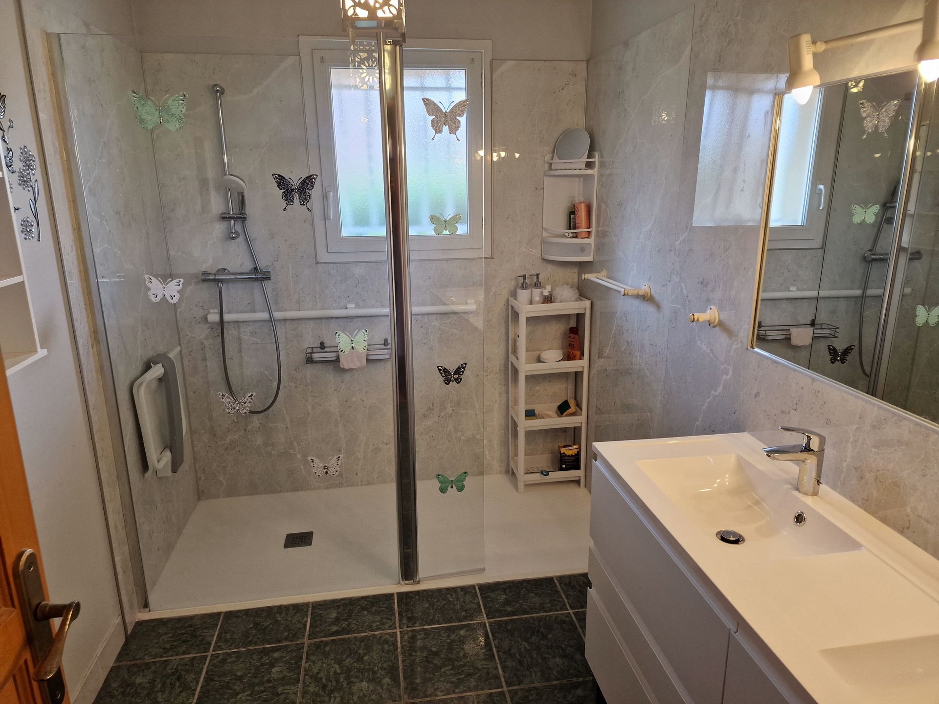 Une salle de bains avec des papillons sur la paroi de la douche