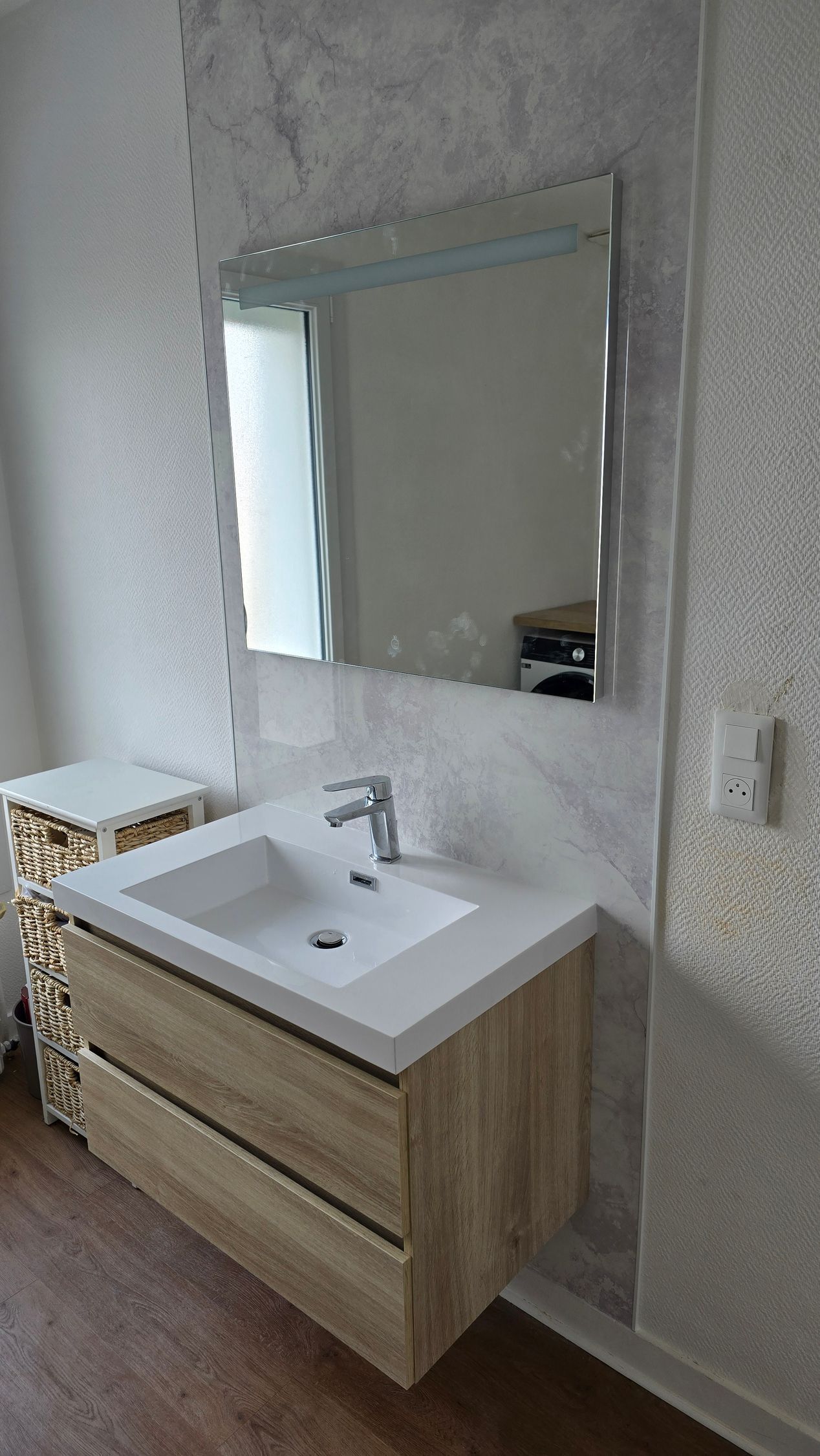 Un meuble vasque sous un miroir