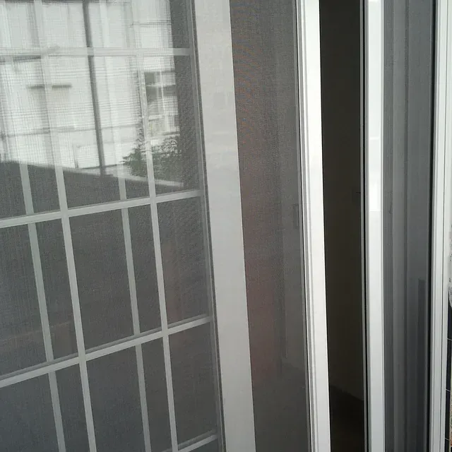 Una puerta corrediza de vidrio con una mosquitera.