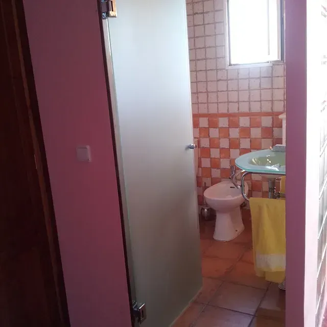 Un baño con inodoro, lavabo y ventana.