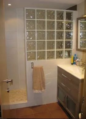 Un baño con lavabo, espejo y ducha.