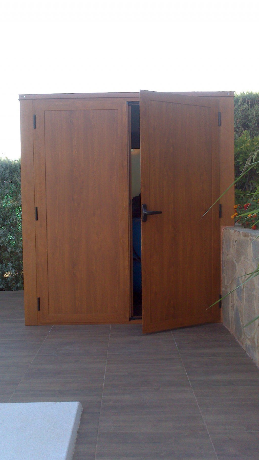 Una puerta de madera está abierta sobre una terraza de madera.