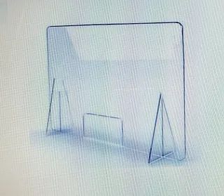 Una barrera de acrílico transparente con un marco de metal está sobre una mesa.