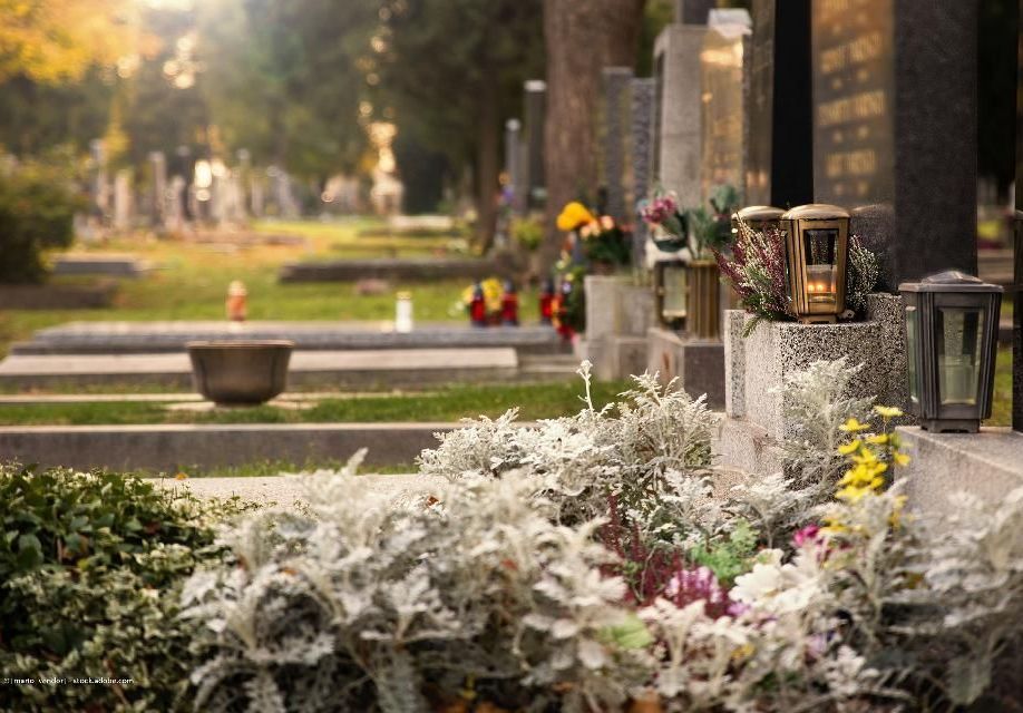 Geschmückte Gräber mit Blumen und Kerzen auf einem Friedhof in Mönchengladbach