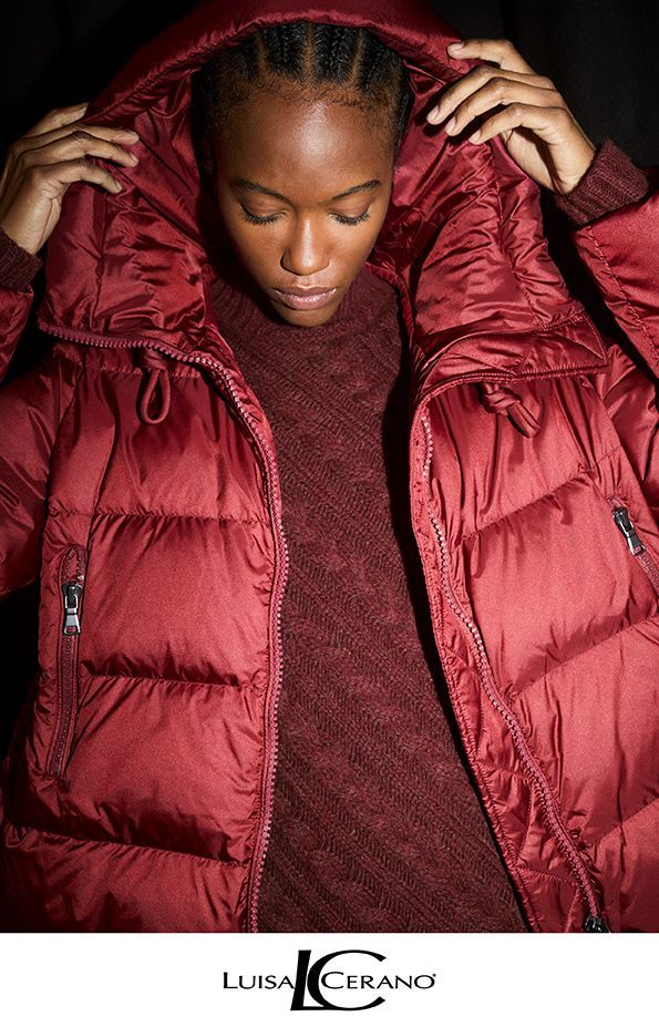 Frau in burgunderfarbenem Puffermantel mit Kapuze, Kopf und Schultern.