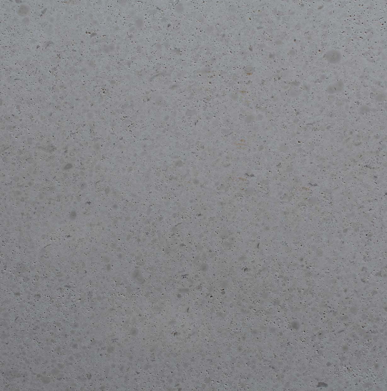 Un primer plano de una superficie gris con pequeños puntos sobre ella.