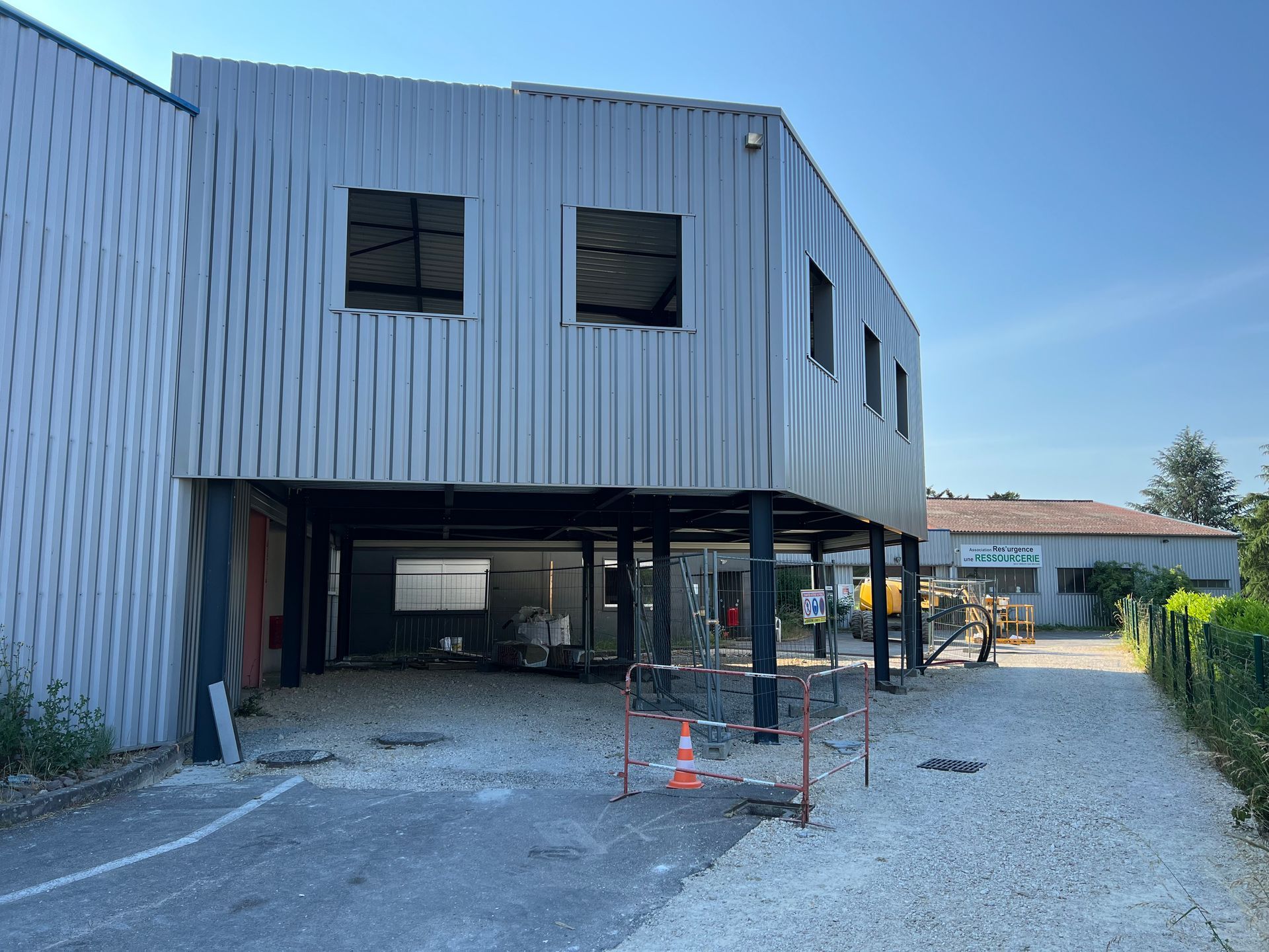 Bâtiment en construction, partie surélevée avec revêtement en tôle ondulée, espace ouvert en dessous