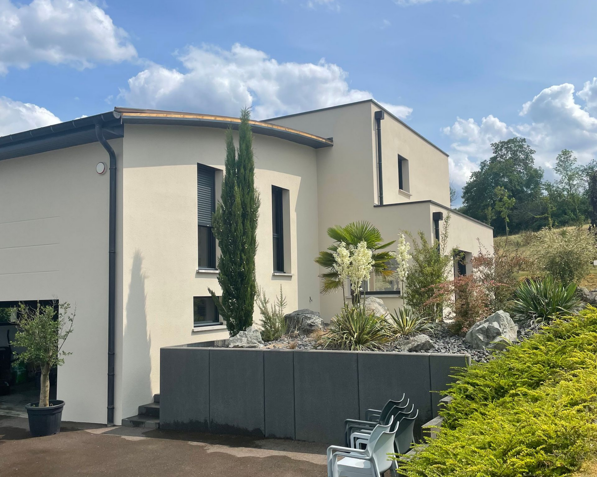 Maison beige moderne et aménagement paysager
