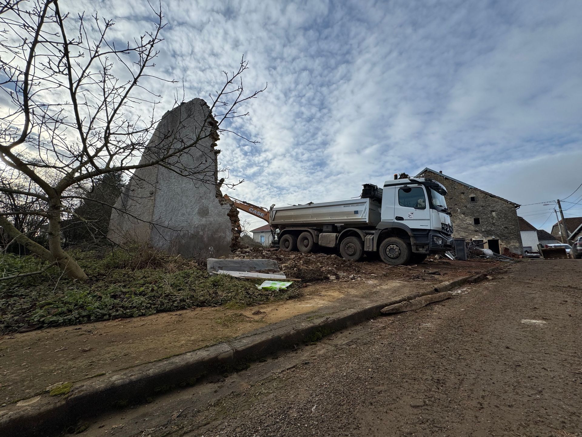 Un camion de construction près d'un bâtiment partiellement démoli
