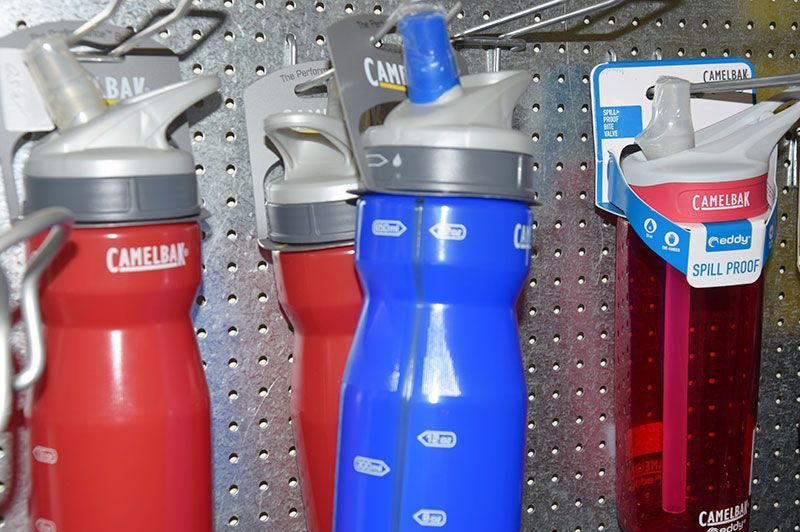 Mehrere Camelbak-Wasserflaschen sind an einer Wand aufgereiht