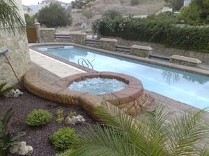 Una gran piscina con un jacuzzi en el medio.