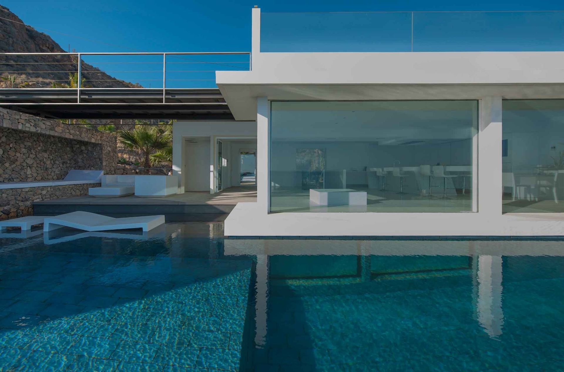 Una casa moderna con piscina delante de ella.