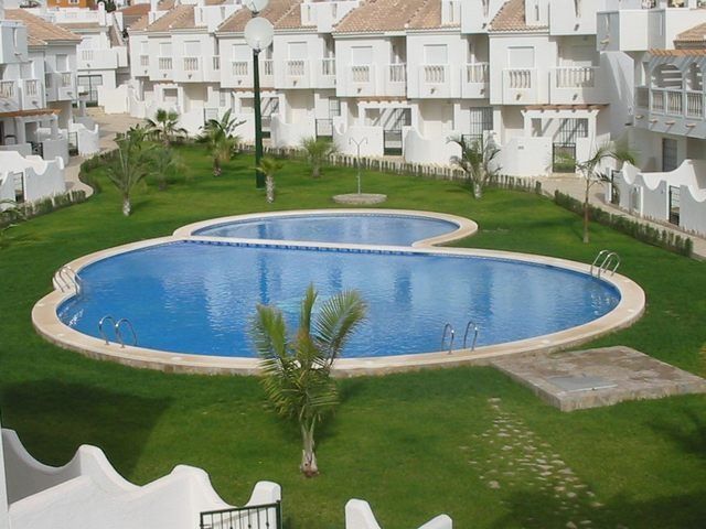 Una gran piscina en medio de un exuberante campo verde.