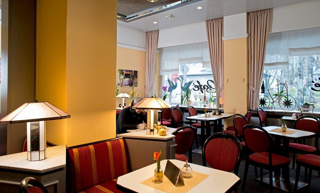 roten Stühle an zwei gedeckten Esstischen im Café