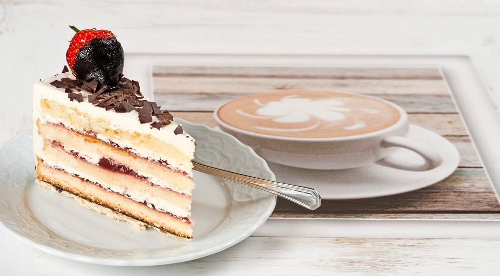Stück Torte mit Schokoraspeln und überzogener Erdbeere