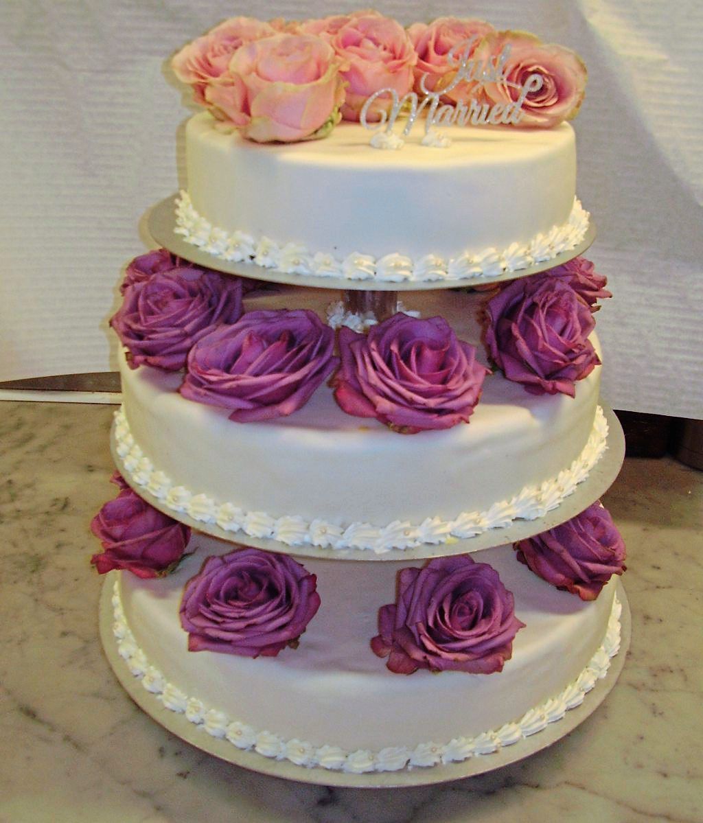dreistöckige weiße Hochzeitstorte mit Blumenverzierung