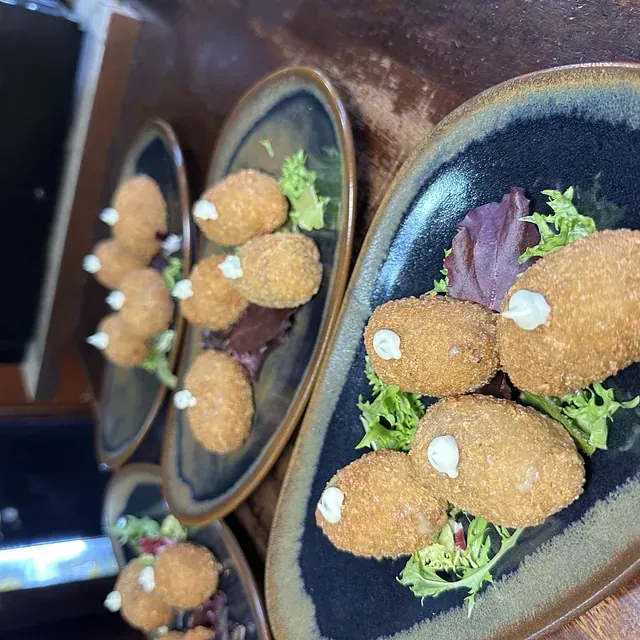 Una fila de platos con comida frita encima