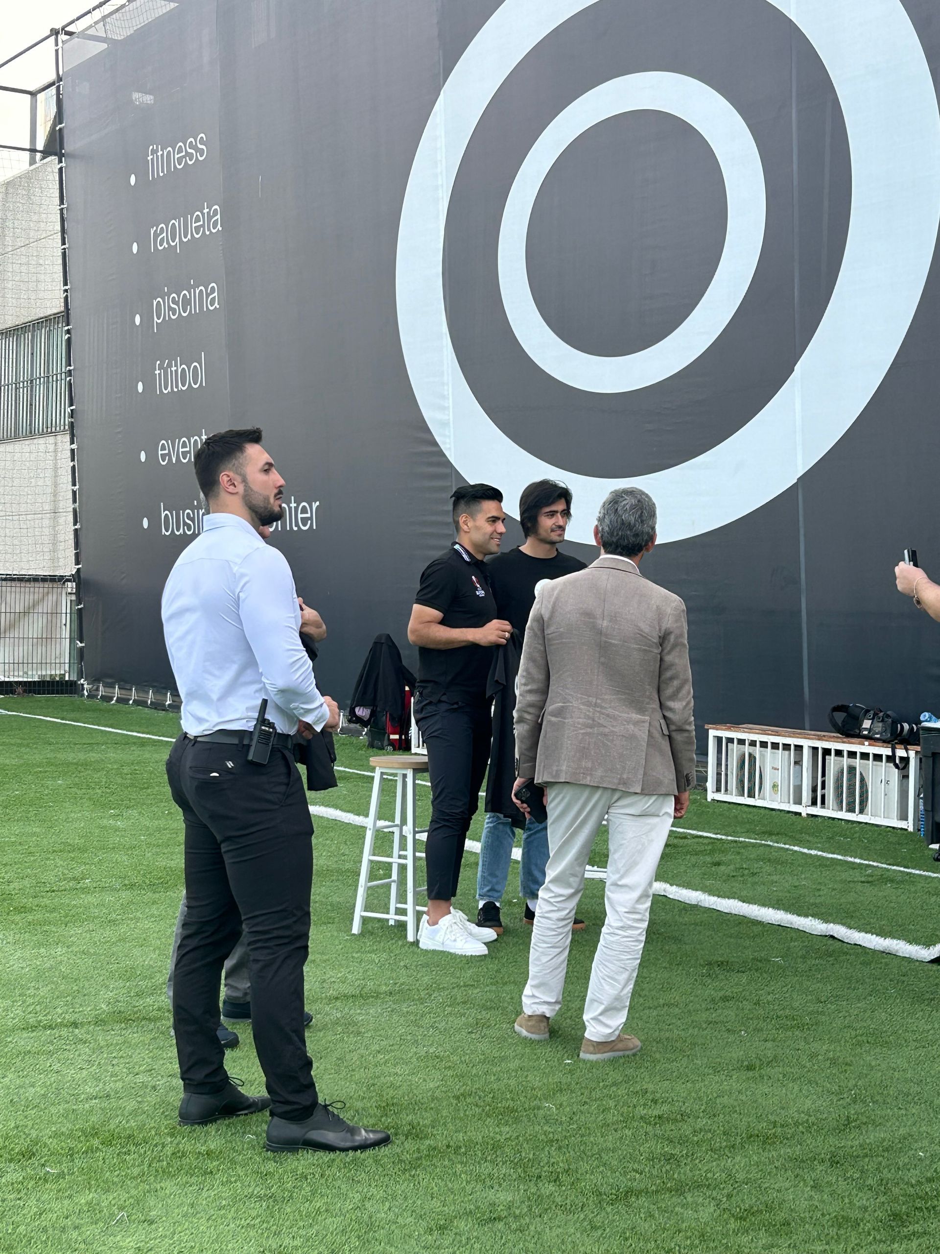 Un grupo de hombres está parado en un campo de fútbol frente a un gran objetivo.
