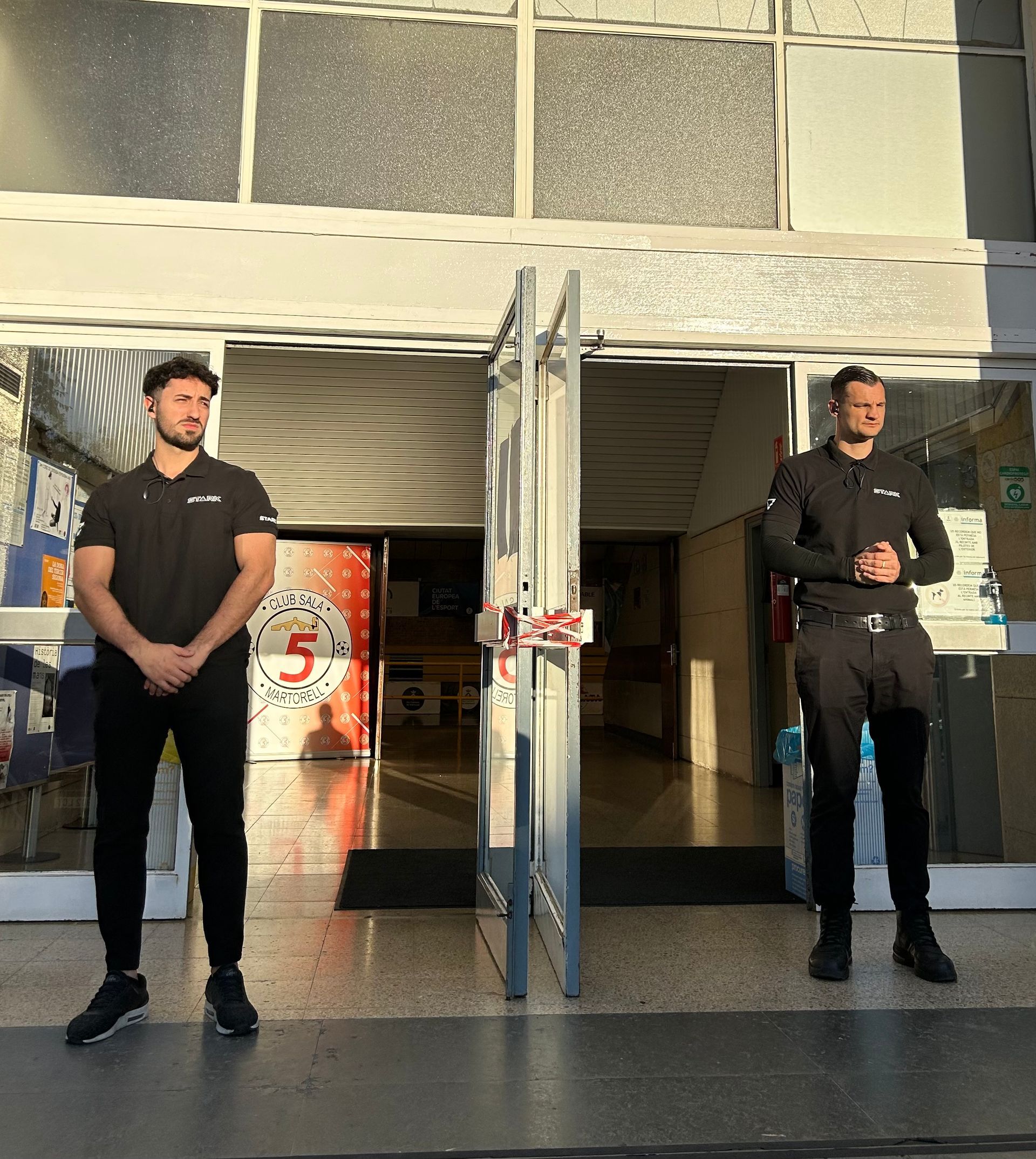 Dos hombres parados frente a un edificio con el número 5 en él.