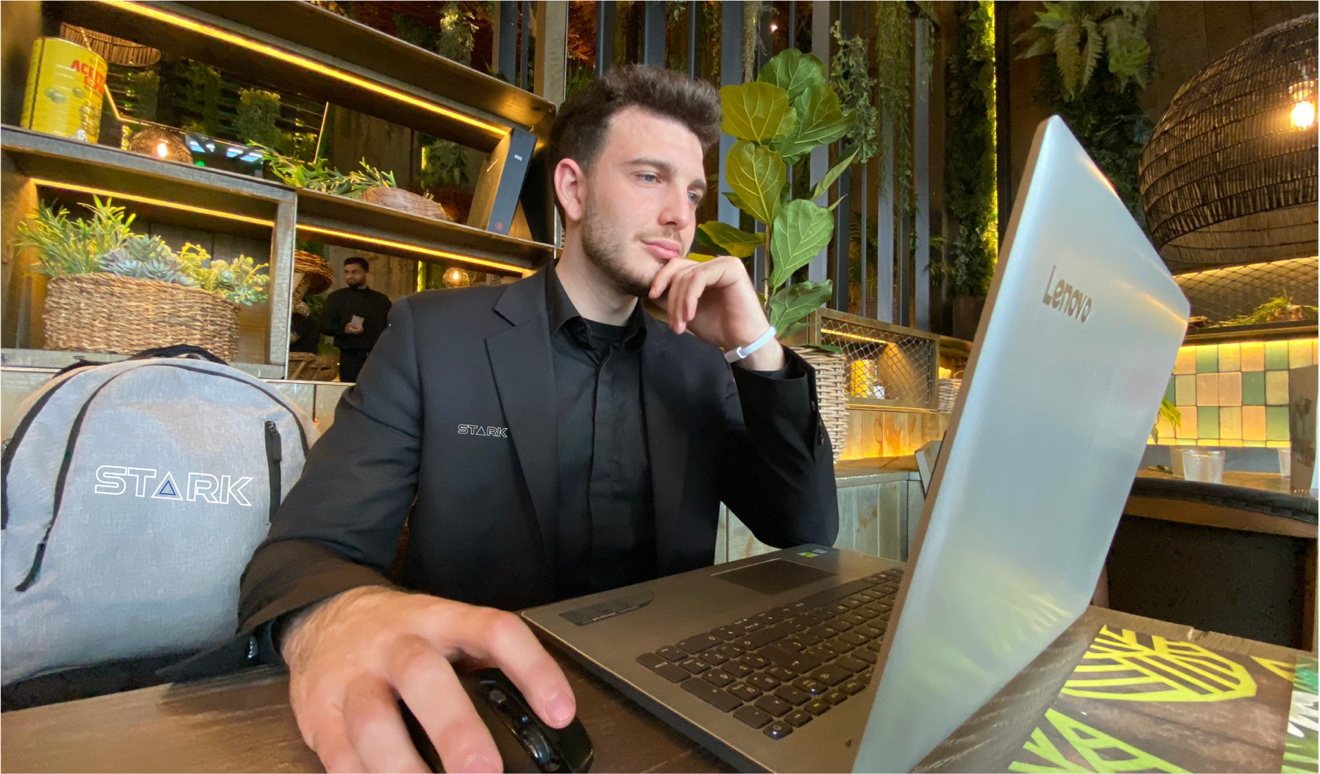 Un hombre con traje está sentado en una mesa utilizando una computadora portátil.