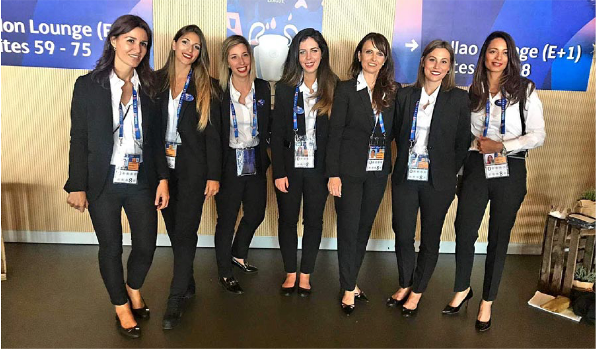Un grupo de mujeres con traje posan para una fotografía.