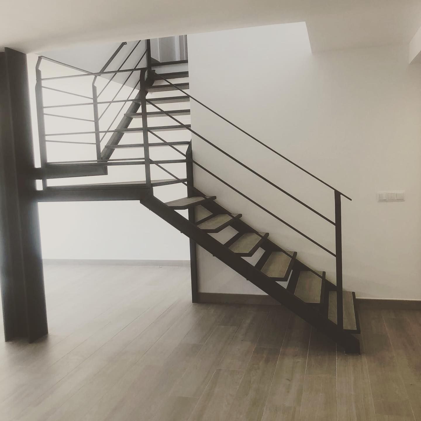 Una habitación vacía con una escalera que conduce al segundo piso.