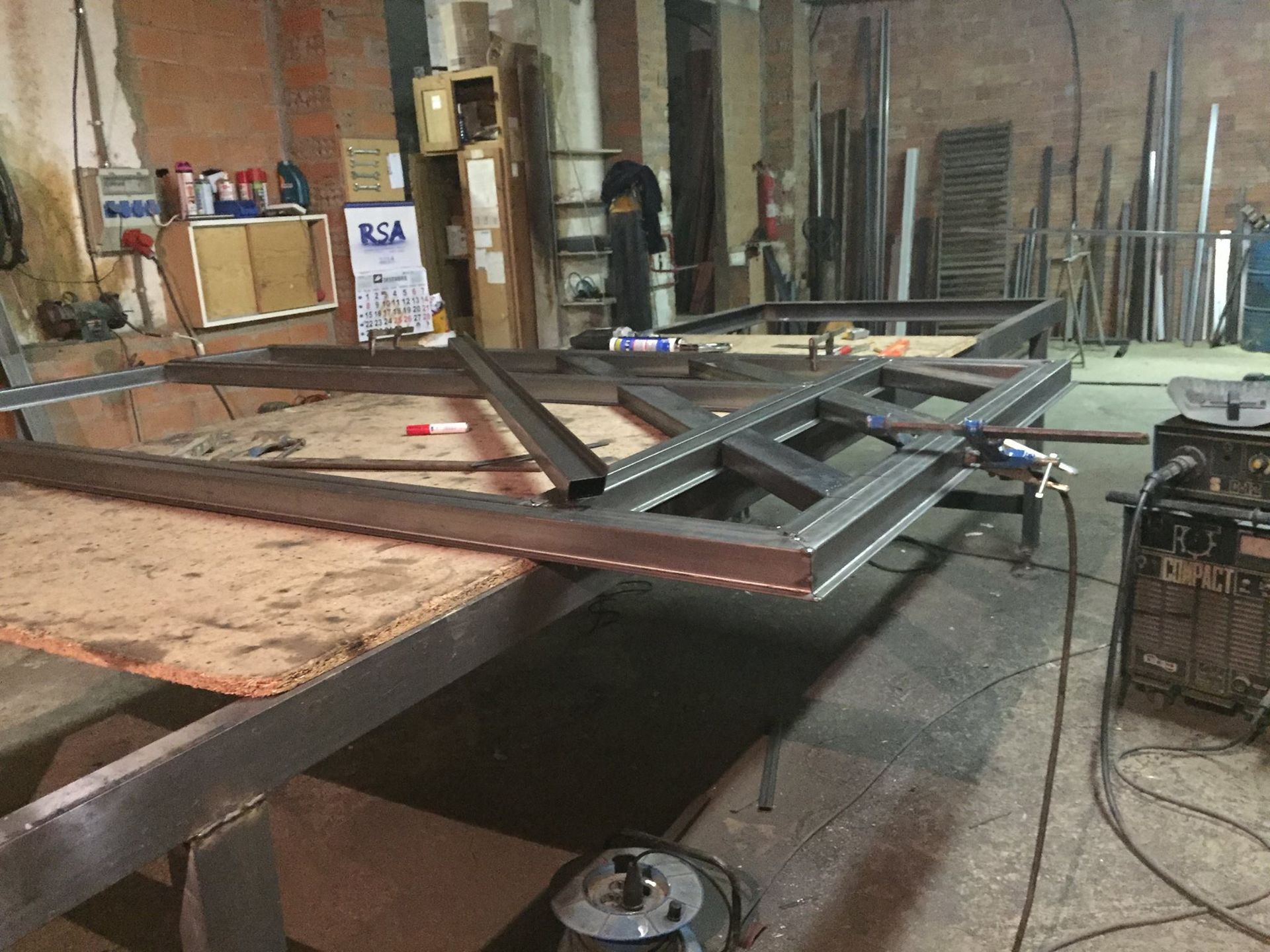 Un marco de metal está colocado encima de una mesa de madera en un taller.