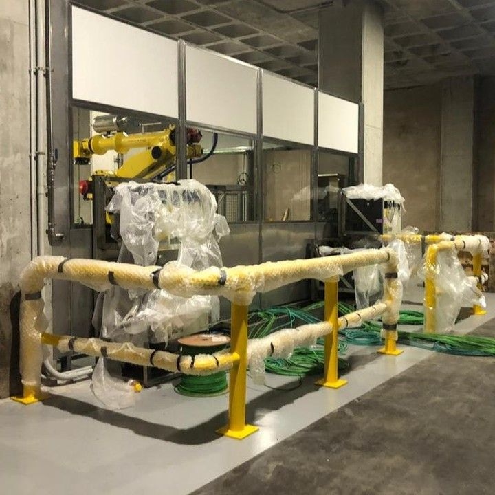Una máquina está envuelta en plástico y está detrás de una barrera amarilla.