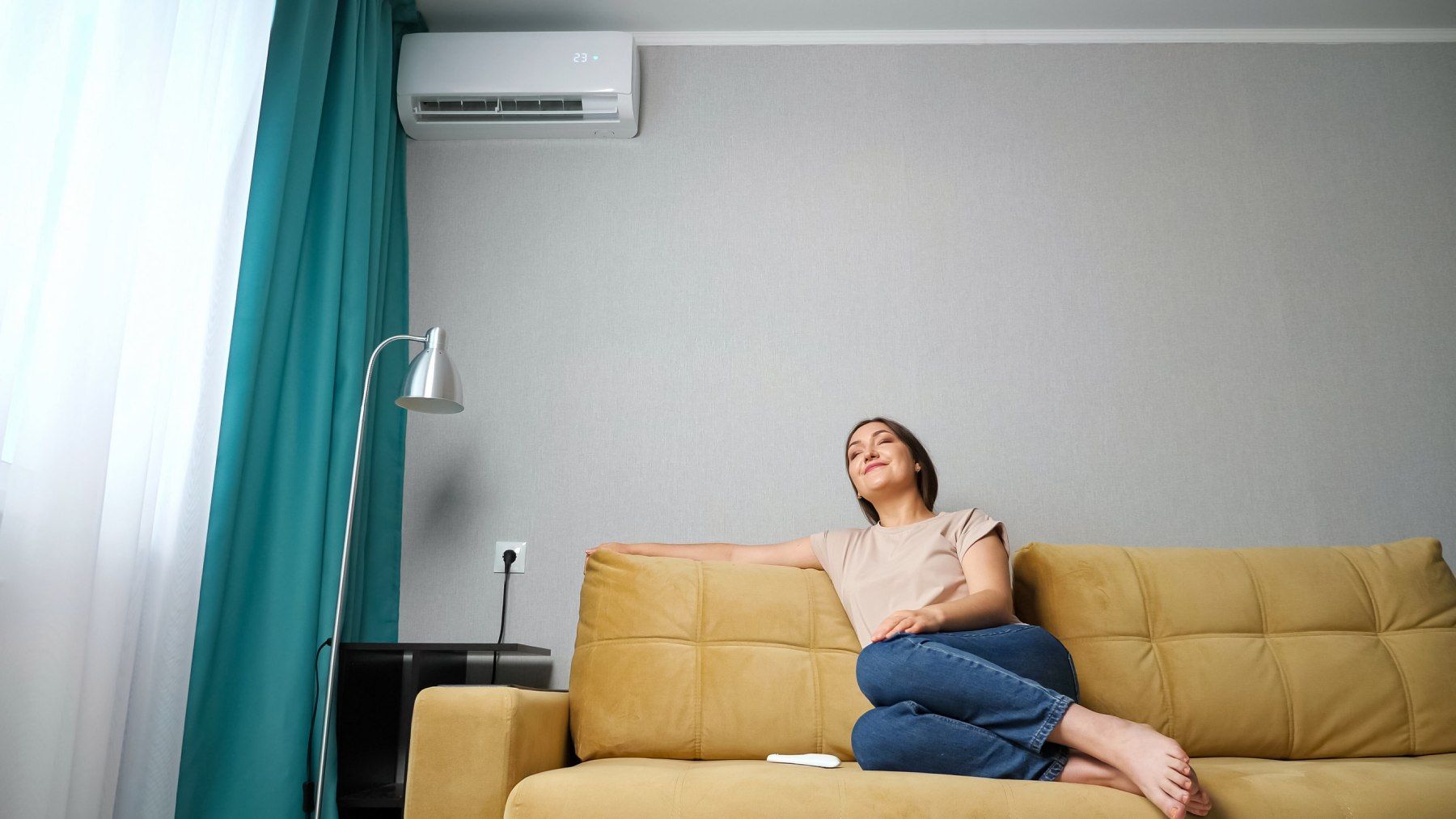 Una mujer está sentada en un sofá en una sala de estar mirando hacia arriba.