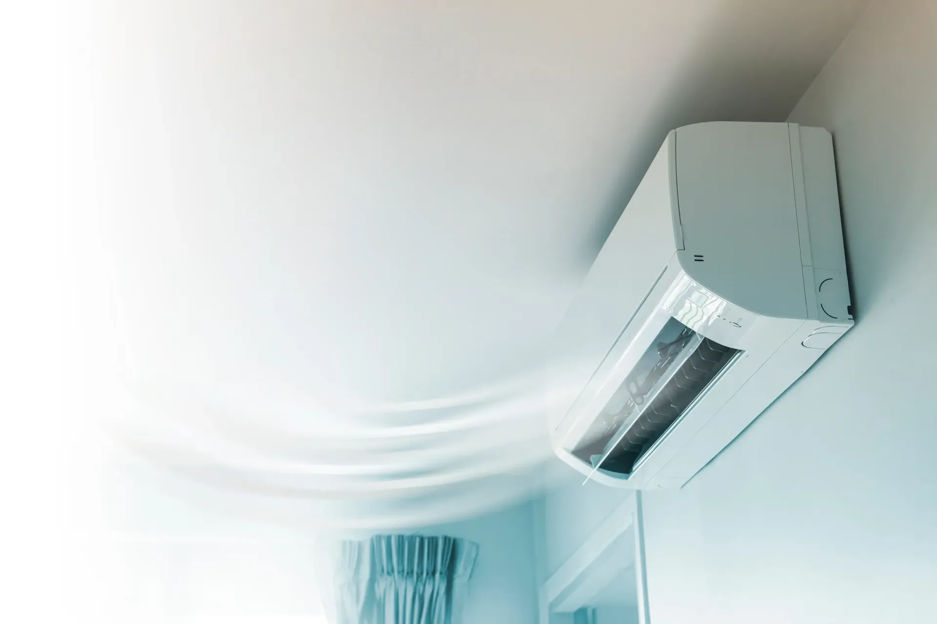 Un acondicionador de aire blanco sopla aire desde el techo de una habitación.