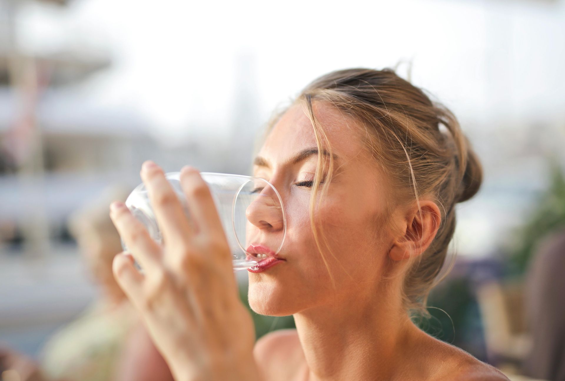Una mujer está bebiendo agua de un vaso.
