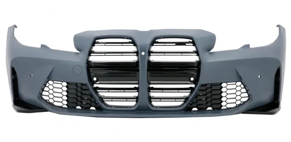 Parachoques de coche de color gris con grandes rejillas en forma de riñón y malla de nido de abeja de color negro.