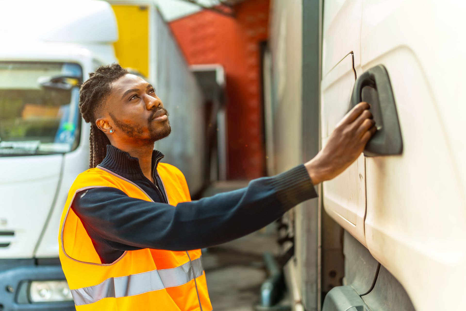 Jeune homme tenant la poignée d'une porte de camion