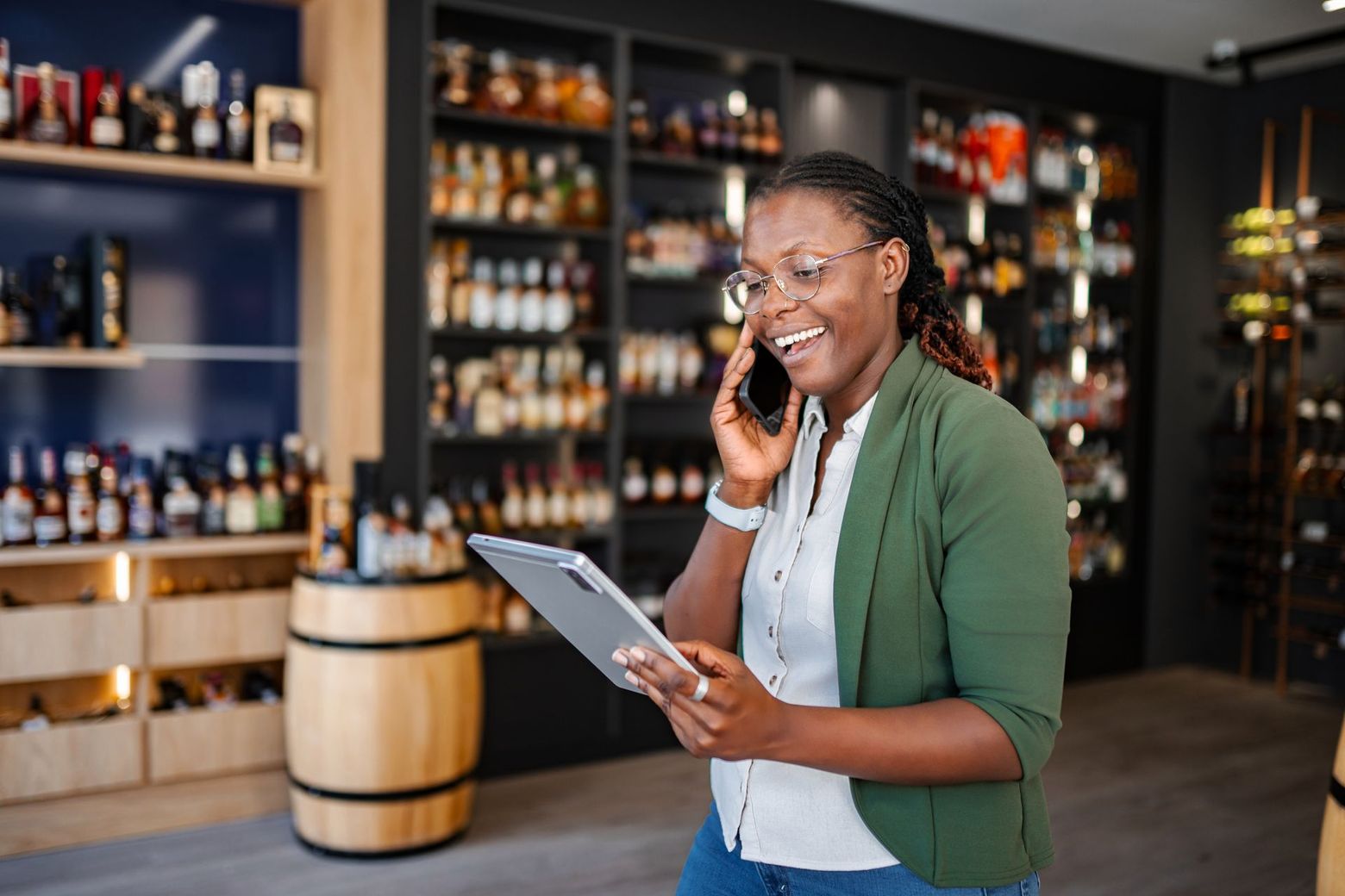 Femme au téléphone dans sa boutique de vins et spiritueux