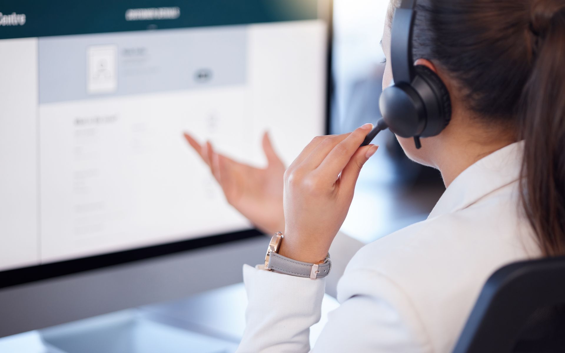 Un agent du service client portant un casque parle à un écran d'ordinateur
