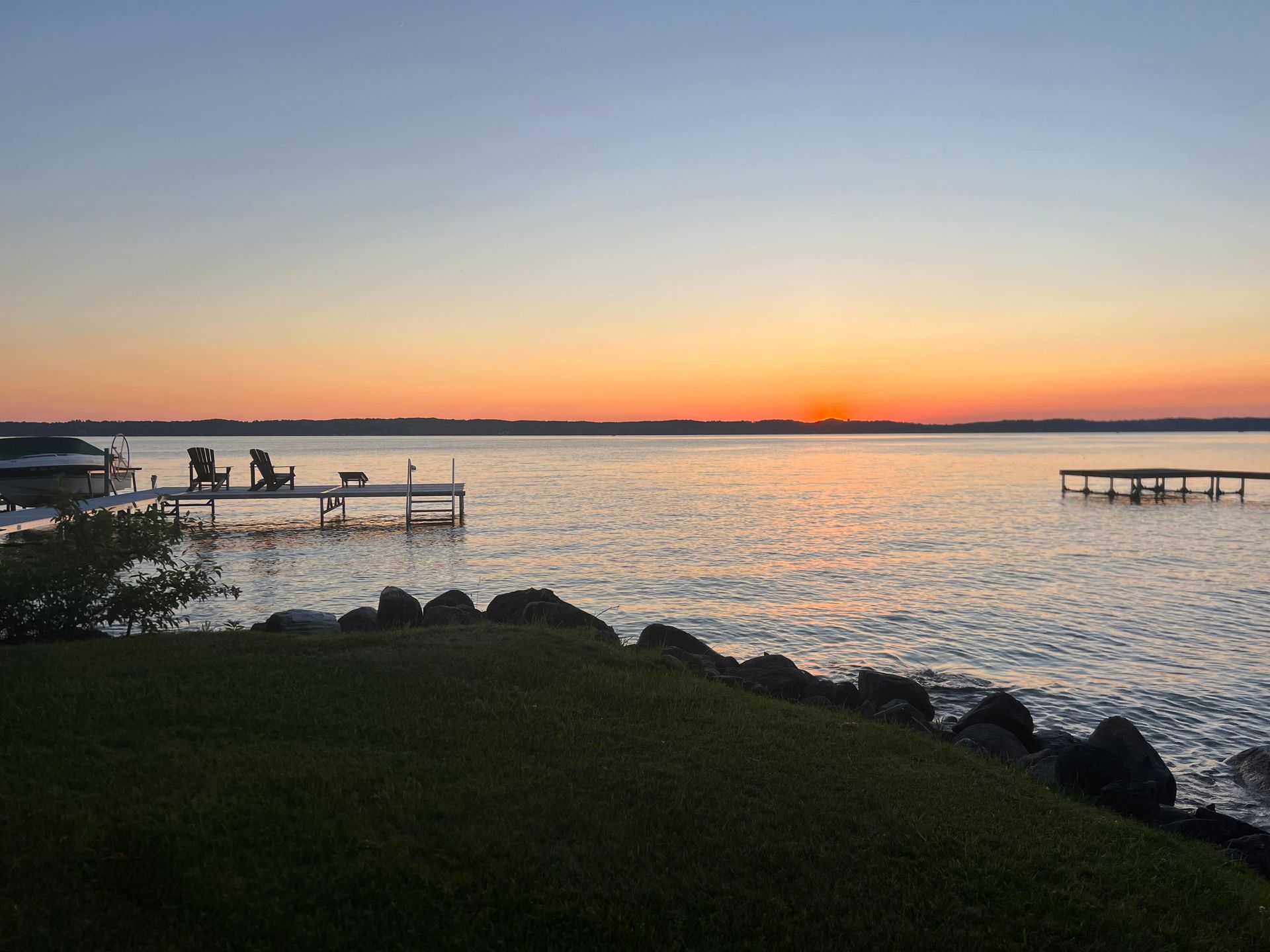 Sunset on lake with swimming docks and chairs
