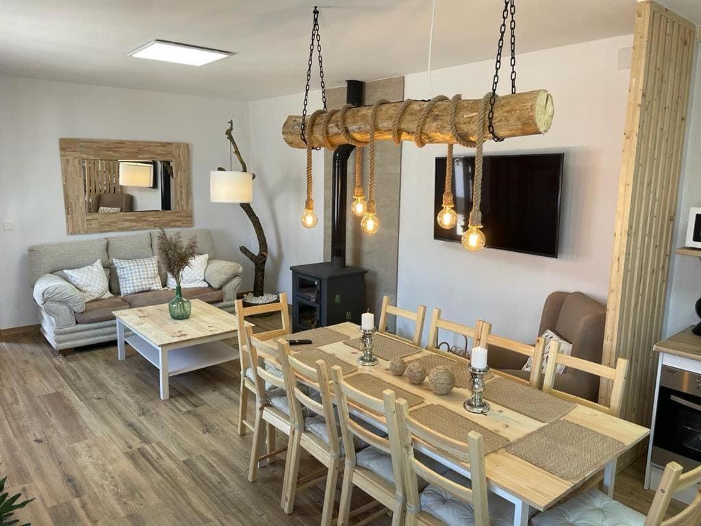 Una sala de estar con una mesa de comedor y sillas y un sofá.