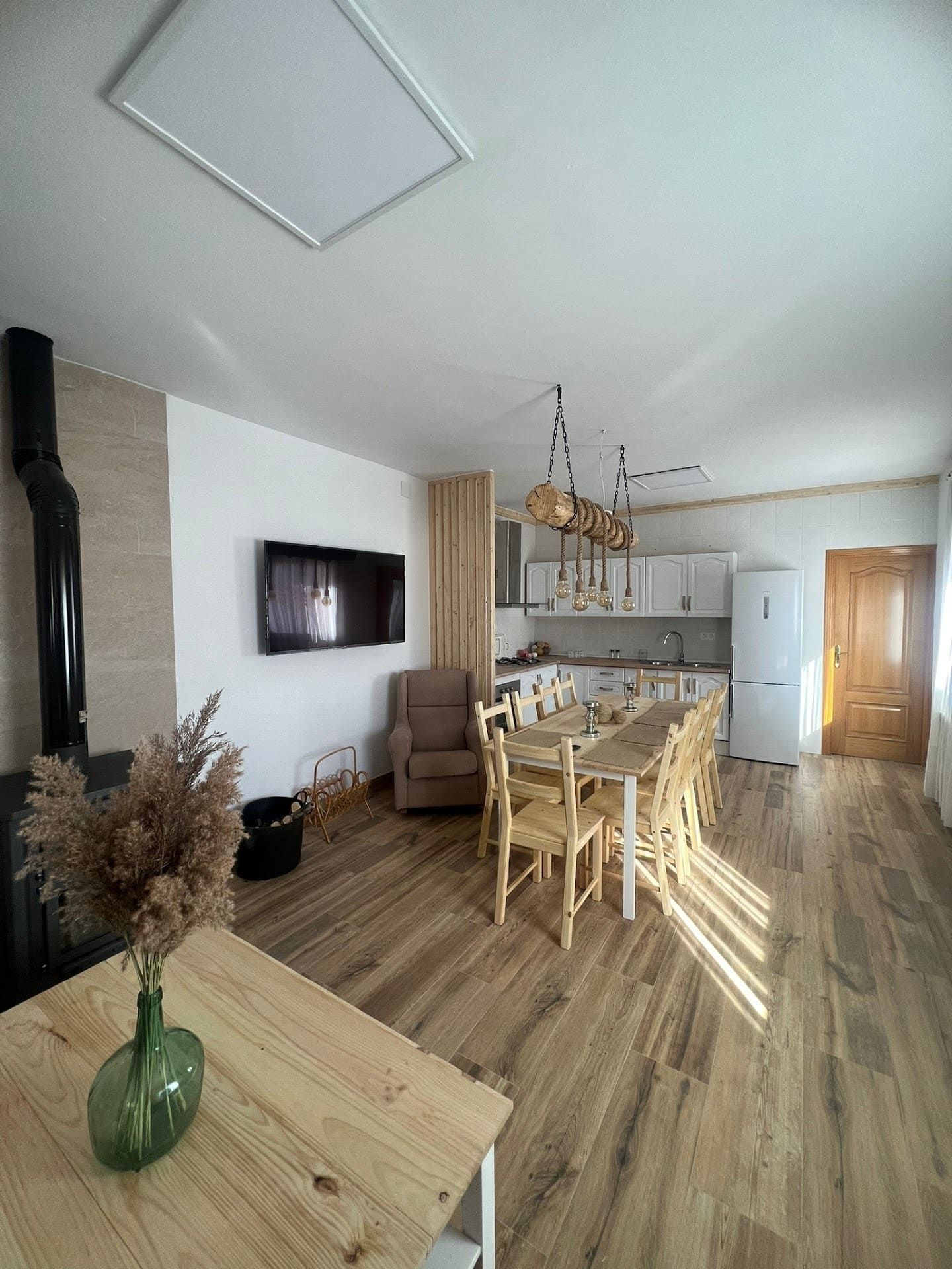 Hay un jarrón con flores en la mesa de la sala de estar.