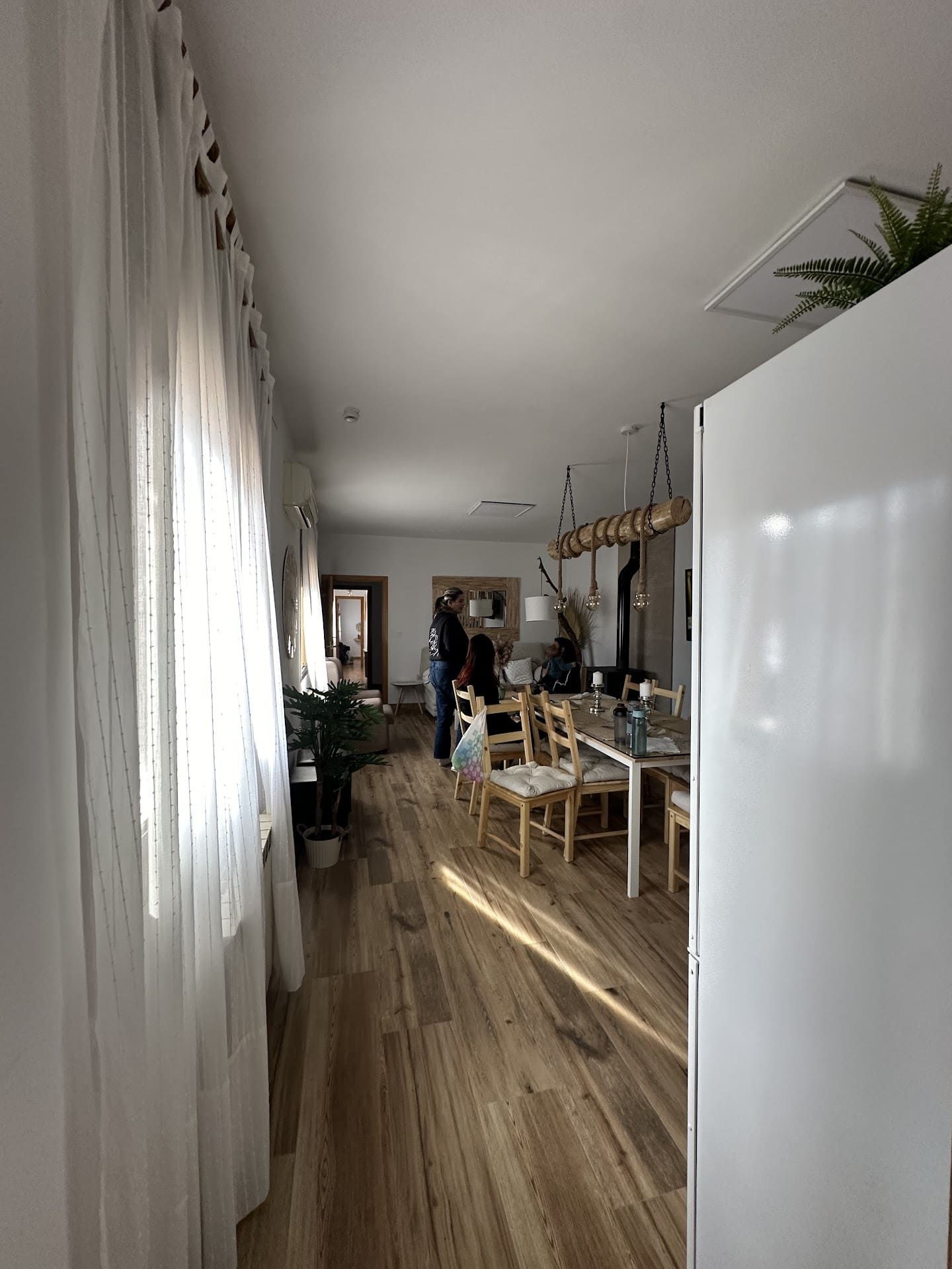 Un largo pasillo que conduce a un comedor con una mesa y sillas.