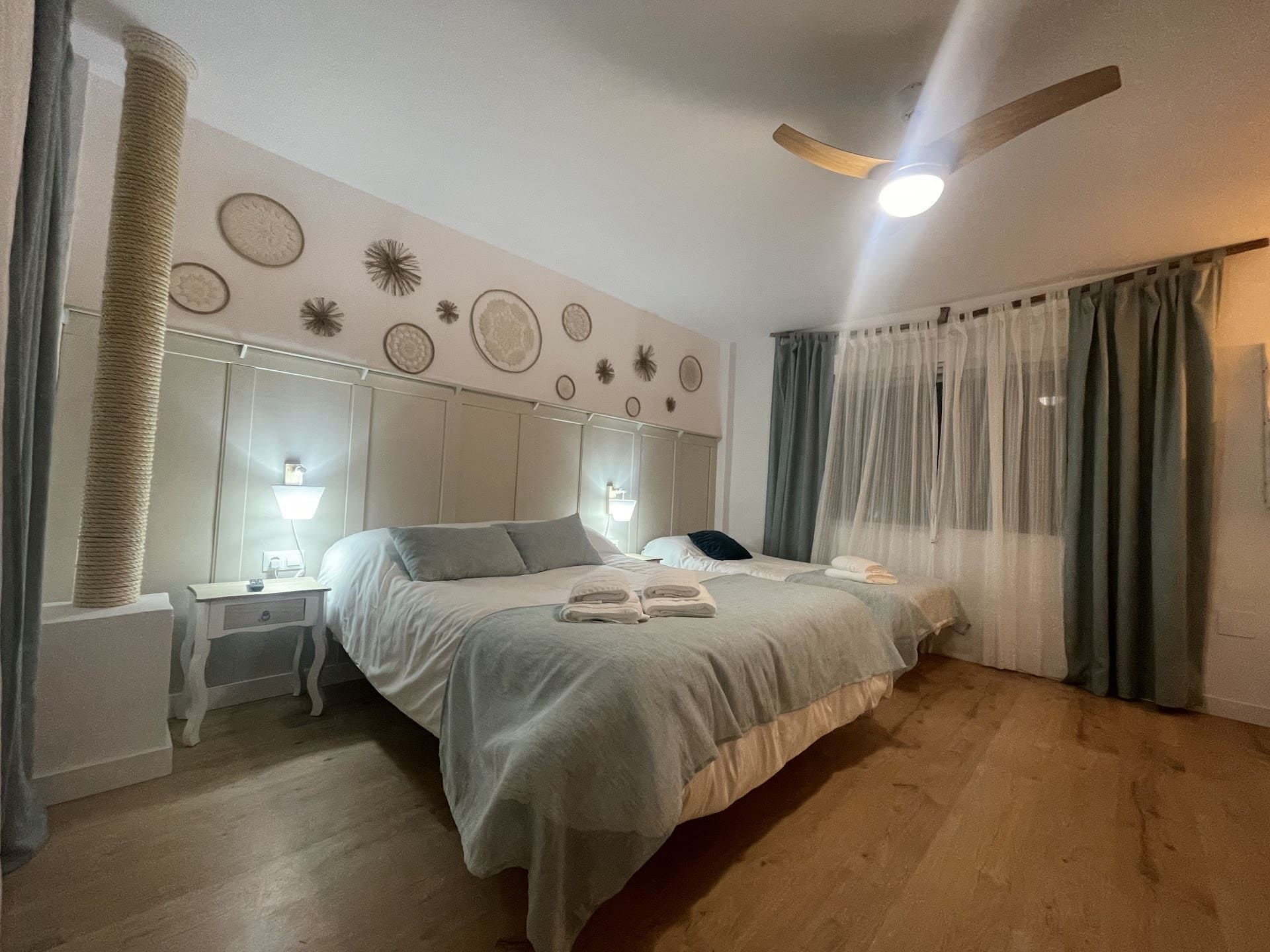 Un dormitorio con dos camas y un ventilador de techo.