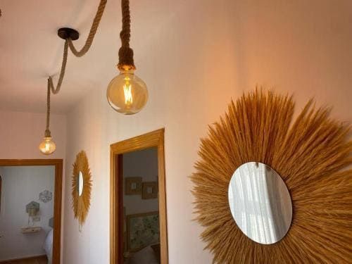 Un pasillo con un espejo y una bombilla colgando del techo.