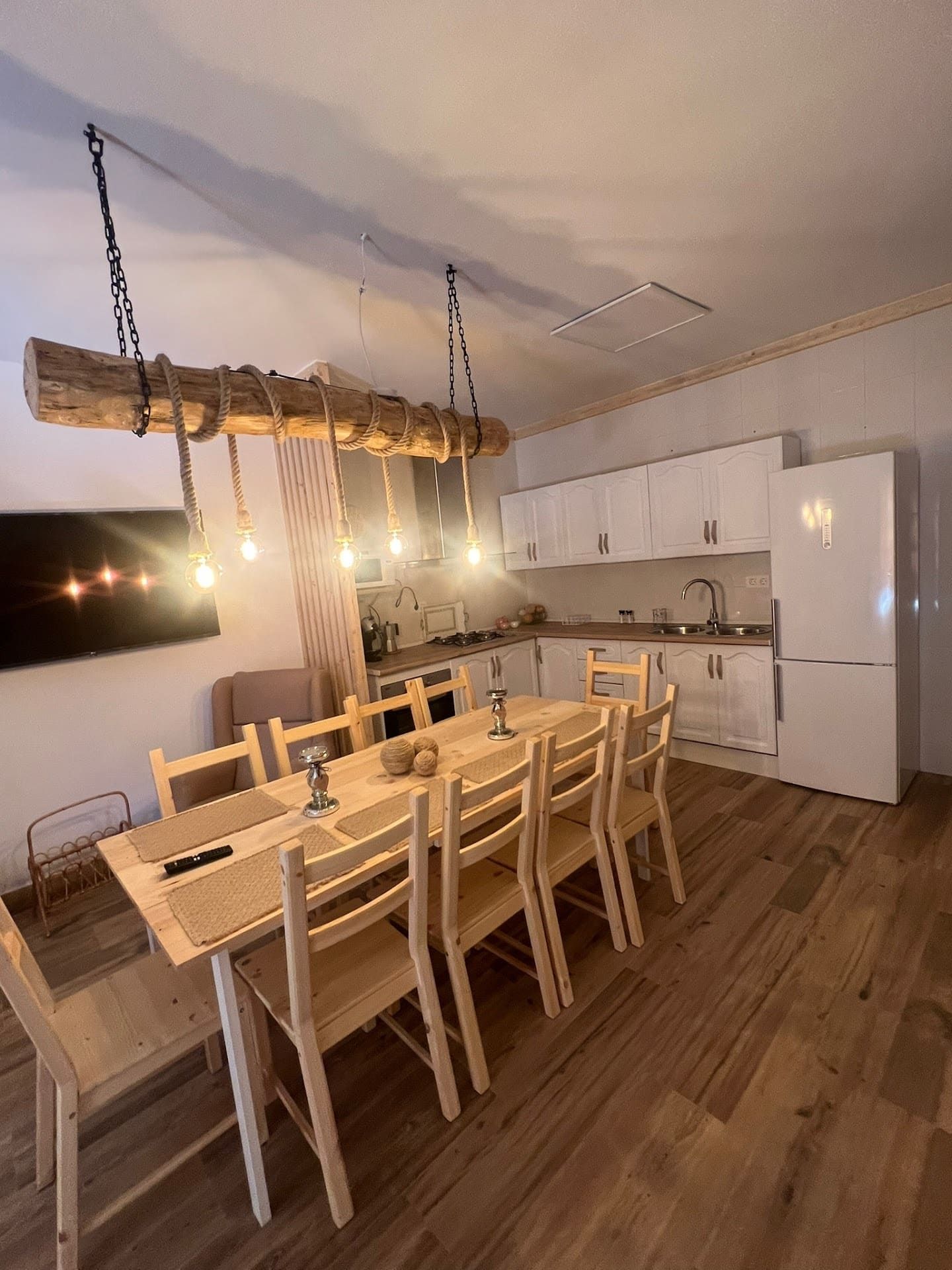 Una cocina con una larga mesa de madera y sillas.