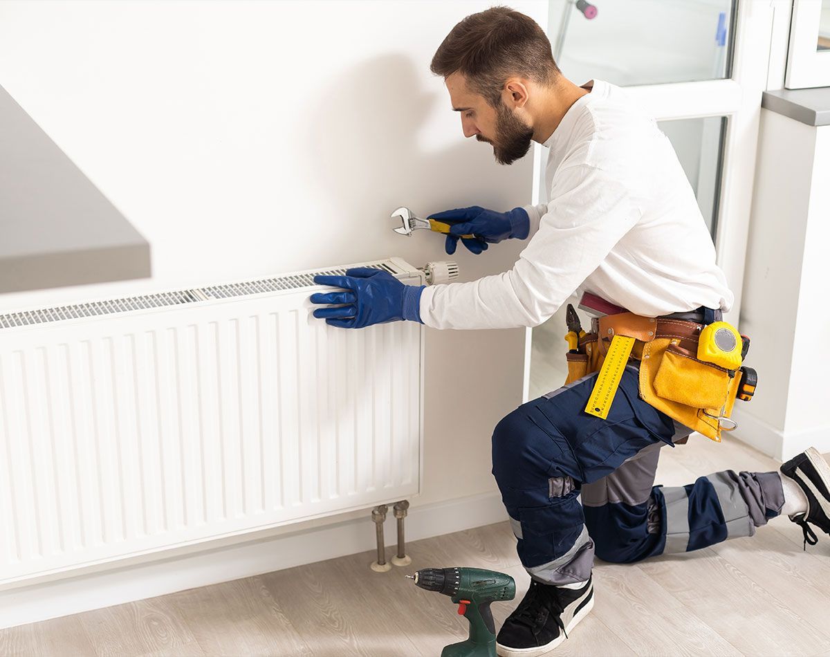 Entretien d'un radiateur effectué par un ouvrier