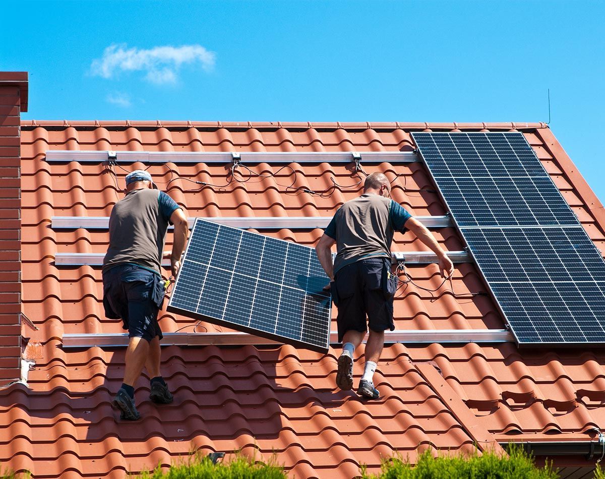 Ouvrier marchant sur une toiture et œuvrant à la mise en place de panneaux solaires