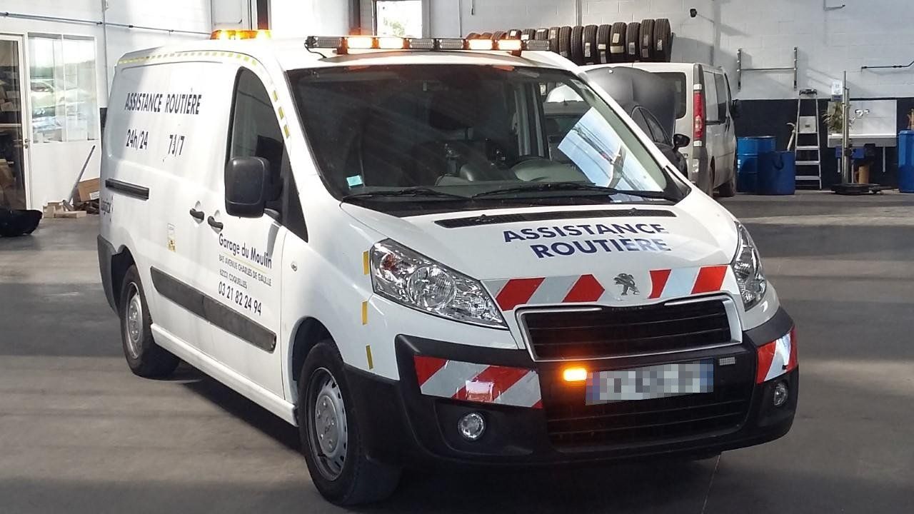 Camion de dépannage d'urgence avec écrit assistance routière dessus