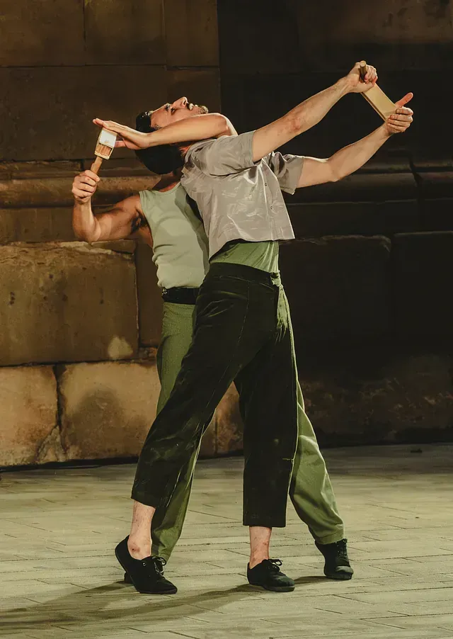 Una pareja de hombres están bailando juntos en un escenario.