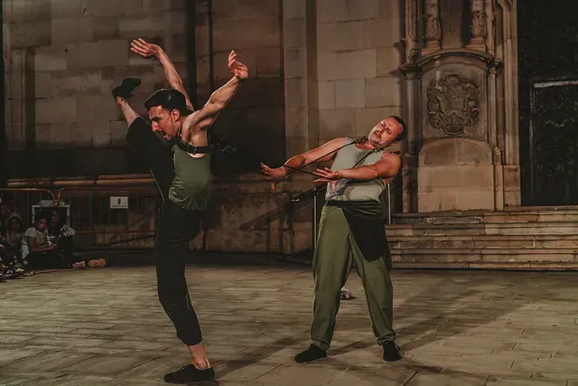 Dos hombres están bailando frente a un edificio.