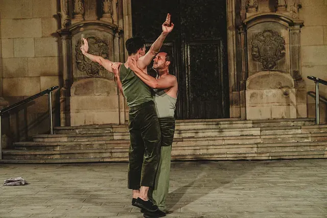 Dos hombres están bailando frente a un edificio.